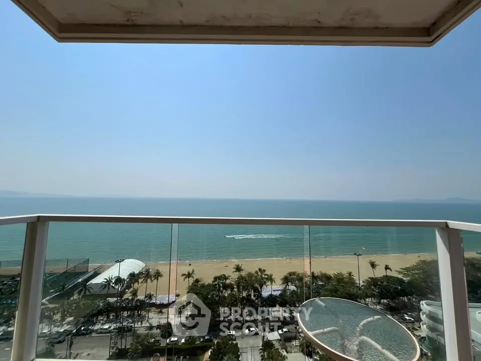 Stunning beachfront balcony view with clear skies and ocean horizon, perfect for seaside living.