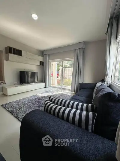 Modern living room with stylish decor and large windows offering natural light.