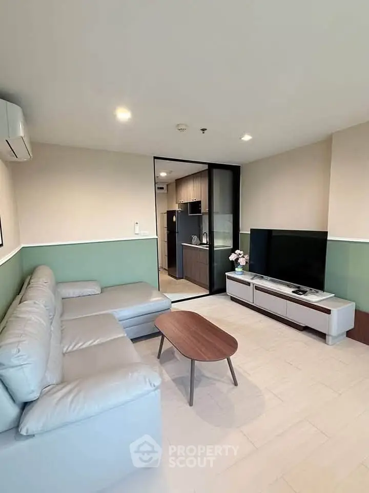 Modern living room with sleek furniture and open kitchen layout in a stylish apartment.