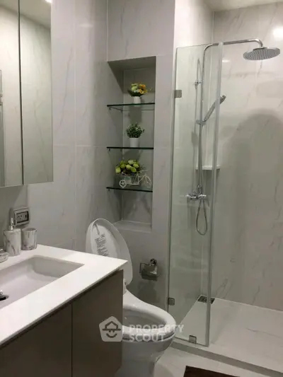 Modern bathroom with glass shower and sleek fixtures in a contemporary apartment.