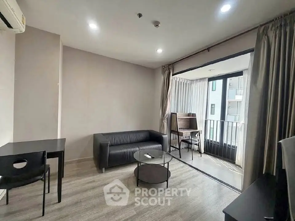 Modern living room with sleek furniture and balcony access in a stylish apartment.
