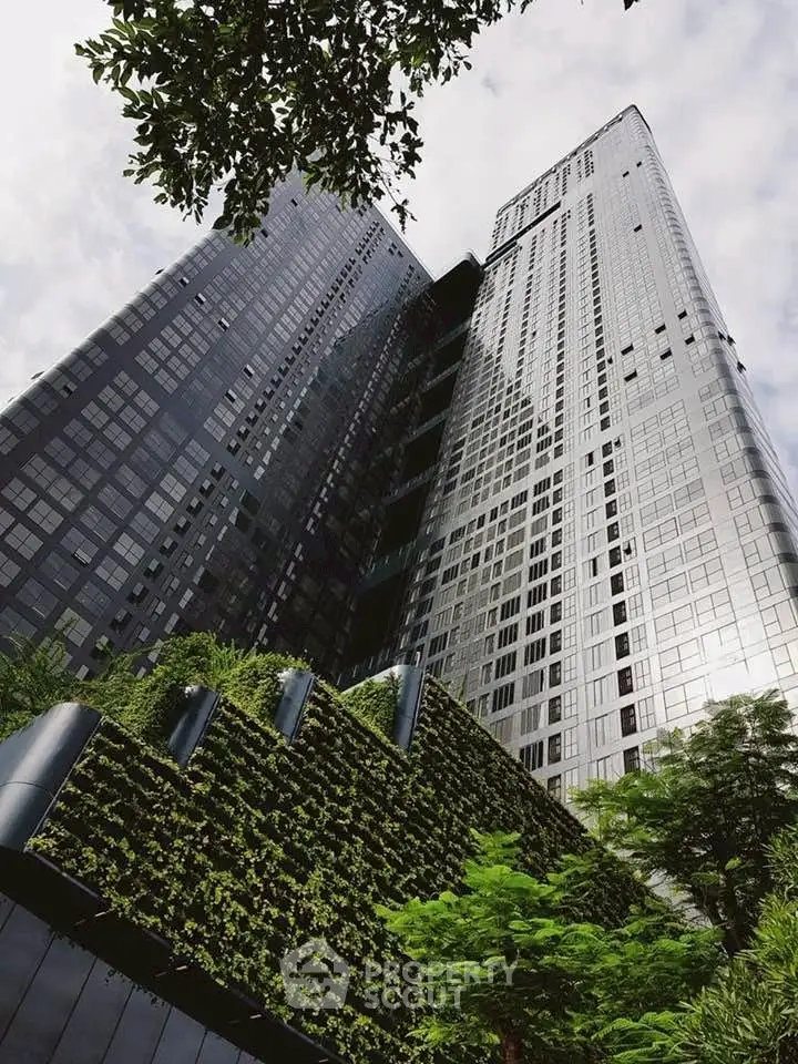 Stunning modern skyscraper with lush green vertical garden and sleek glass facade.