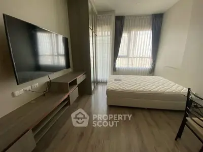 Modern bedroom with large window, sleek TV setup, and minimalist decor.