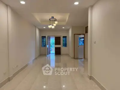 Spacious modern living room with elegant lighting and glossy tiled flooring, perfect for family gatherings.