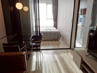Modern studio apartment with glass partition, cozy living area, and natural light.