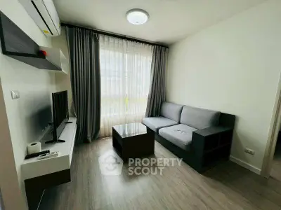 Modern living room with sleek furniture and large window, perfect for cozy relaxation.