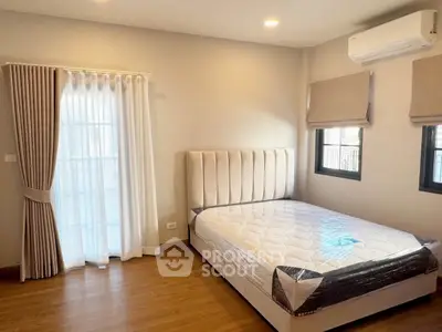 Spacious bedroom with natural light, featuring a new bed and modern air conditioning.
