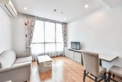 Bright and modern living room with wooden flooring and large window, perfect for relaxation.