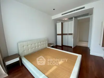 Spacious bedroom with modern design and wooden flooring in a luxury apartment.