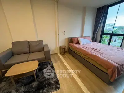 Cozy bedroom with a sofa and large window offering a scenic view