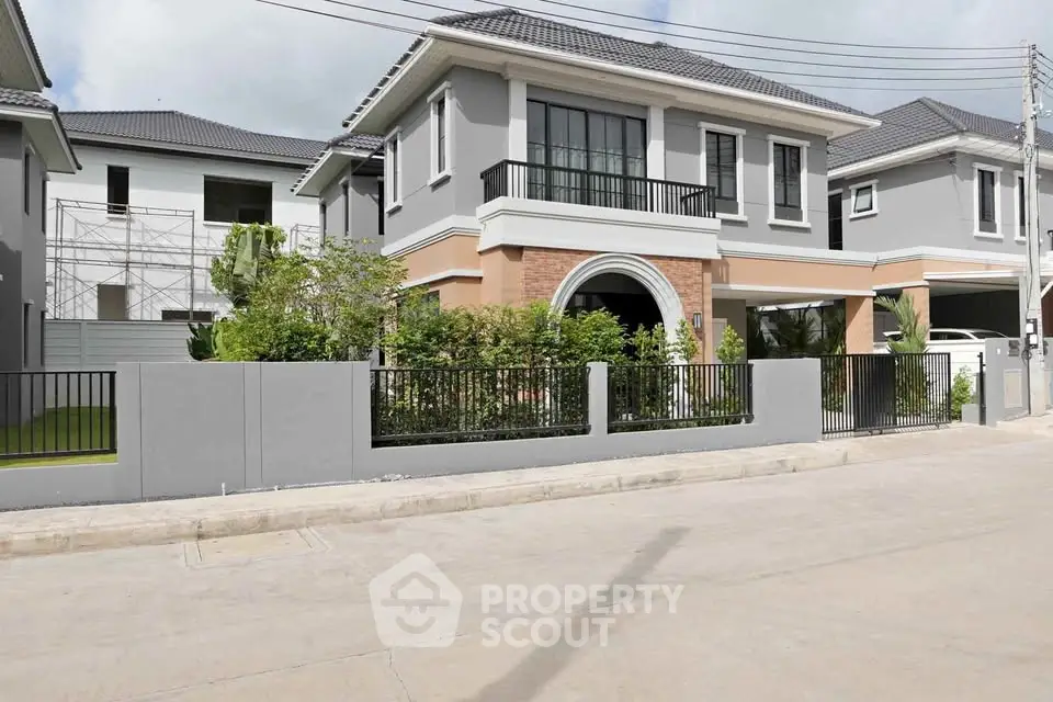 Modern two-story house with landscaped garden and sleek exterior design.