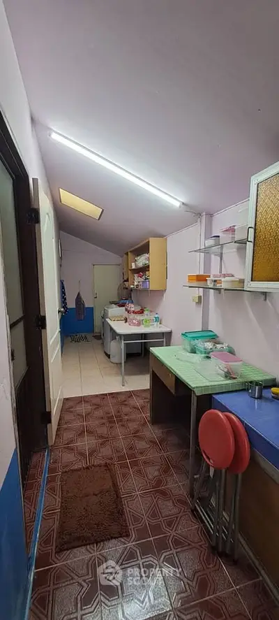 Cozy kitchen with closed layout and colorful decor, featuring ample storage and natural light.
