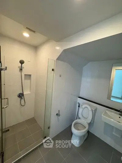 Modern bathroom with glass shower and sleek fixtures in a contemporary home.