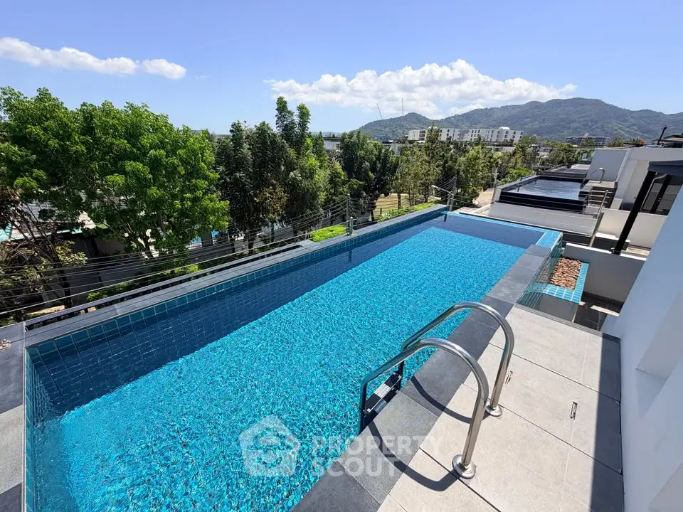 Stunning rooftop pool with panoramic mountain views in modern residential complex.