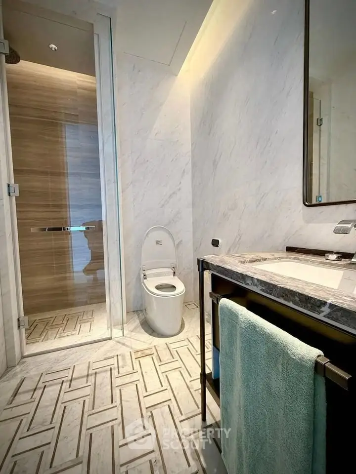 Luxurious modern bathroom with marble finishes and glass shower enclosure