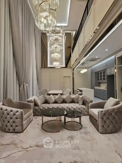 Luxurious living room with high ceilings, elegant chandeliers, and plush seating in a modern open layout.