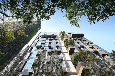 Stunning modern architectural building with lush greenery and unique facade design.