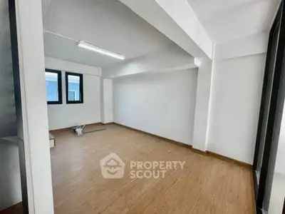 Spacious unfurnished room with wooden flooring and large windows