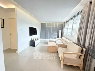 Spacious modern living room with sleek furniture and large windows for natural light.