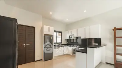 Modern kitchen with sleek white cabinets and stainless steel appliances in a bright, spacious layout.