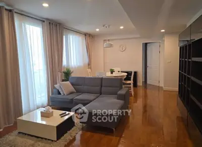 Spacious living room with modern furniture and natural light in a stylish apartment.