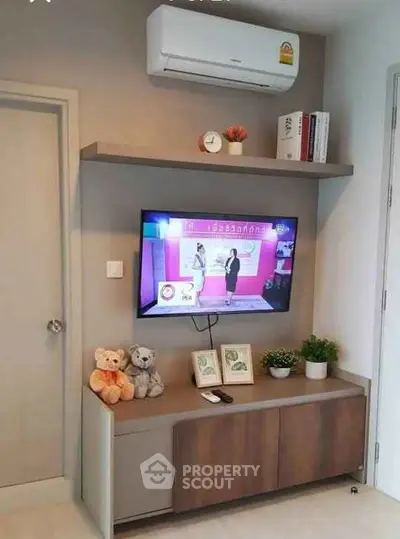 Modern living room with wall-mounted TV and air conditioning unit, stylish shelving and decor.