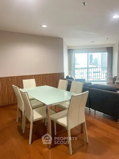 Spacious dining area with modern furniture and city view in a stylish apartment.