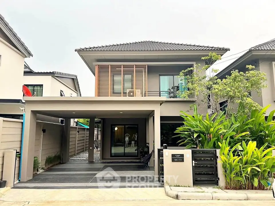 Modern two-story house with sleek design and lush landscaping in a suburban neighborhood.