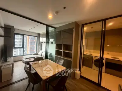 Modern apartment with open living room and kitchen, featuring stylish furniture and large windows.