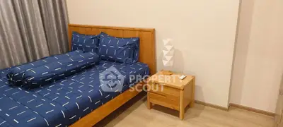 Cozy bedroom with modern wooden furniture and stylish blue bedding.