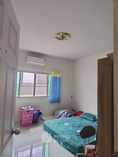 Cozy bedroom with air conditioning and natural light, ideal for comfortable living.