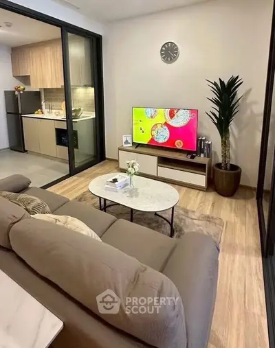 Modern living room with open kitchen, stylish decor, and cozy ambiance.