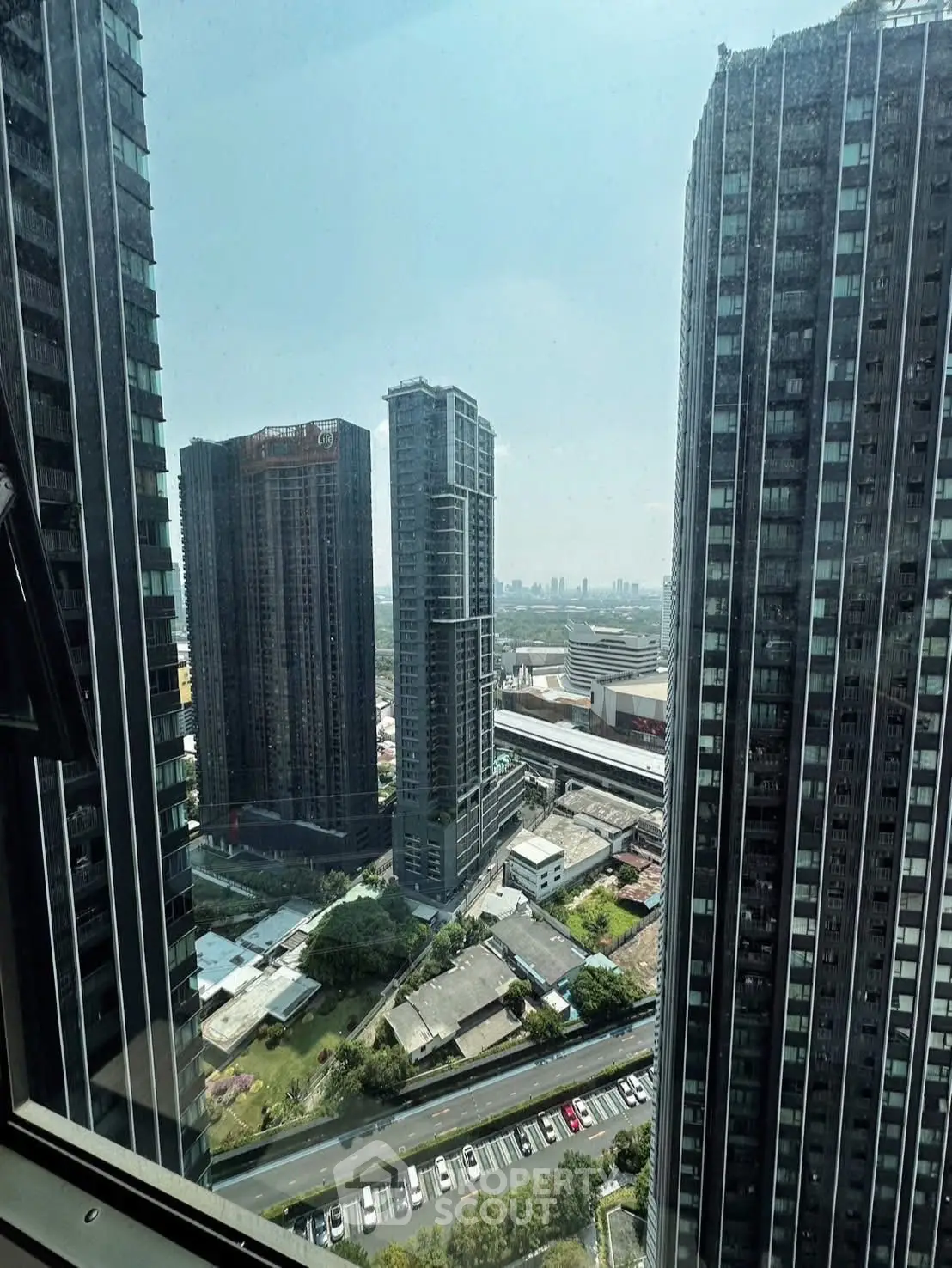Stunning cityscape view from high-rise building window showcasing modern urban architecture.