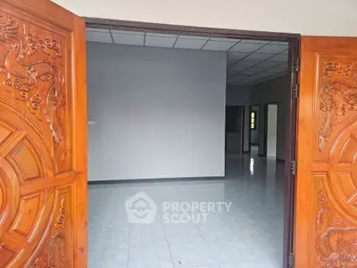 Spacious interior with ornate wooden doors and tiled flooring, perfect for customization.