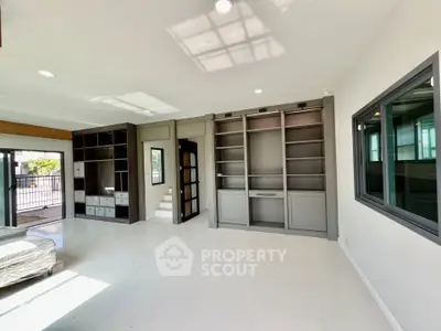 Spacious living room with built-in shelves and large windows for natural light