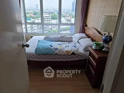 Cozy bedroom with city view, featuring a wooden bed and bedside lamp, perfect for urban living.