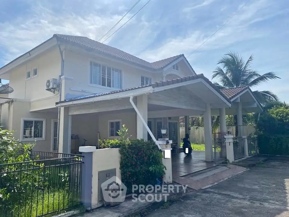 Charming two-story house with spacious driveway and lush greenery