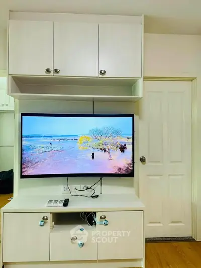 Modern living room with built-in TV cabinet and sleek white door, perfect for cozy entertainment.