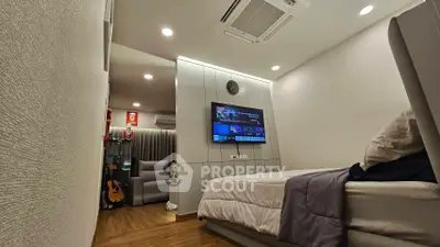 Modern bedroom with wall-mounted TV and cozy lighting