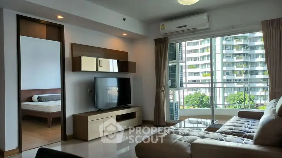 Modern living room with large window and view of cityscape, featuring stylish furniture and sleek design.