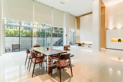 Spacious modern living room with high ceilings and large windows offering natural light.