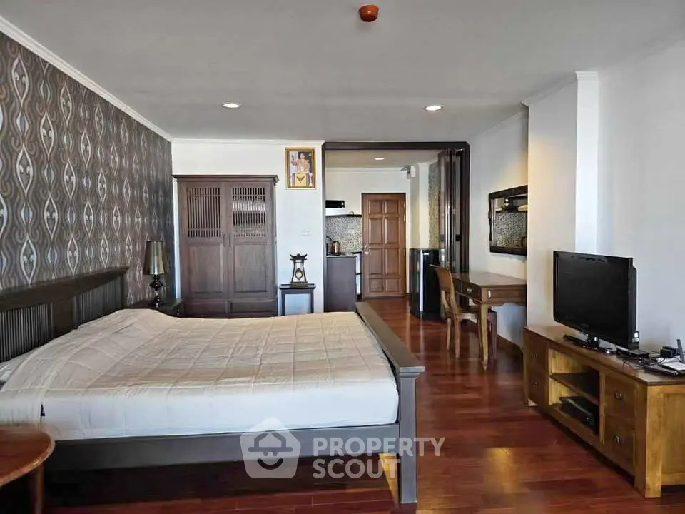 Spacious bedroom with elegant wooden flooring and modern furnishings