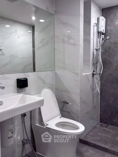 Modern bathroom with sleek design, featuring a shower and contemporary fixtures.