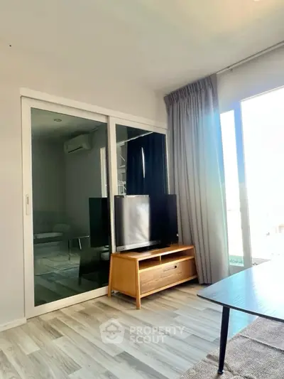 Modern living room with sleek TV stand and large window for natural light.