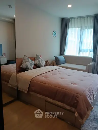 Cozy bedroom with stylish decor and natural light, featuring a comfortable bed and elegant sofa.