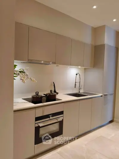 Modern kitchen with sleek cabinetry and built-in oven, perfect for culinary enthusiasts.