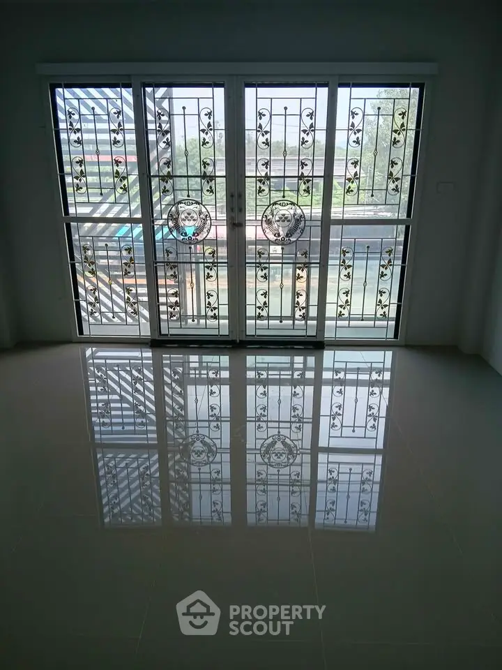 Spacious room with decorative sliding glass doors and elegant floor reflection.