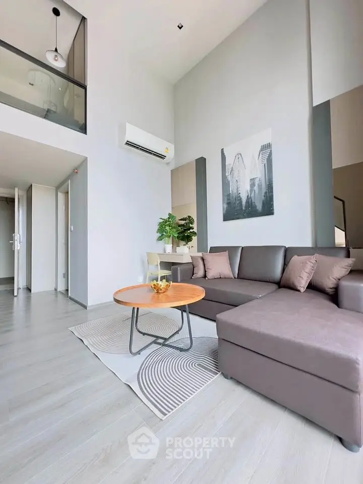 Modern living room with high ceiling and stylish decor in a contemporary apartment.