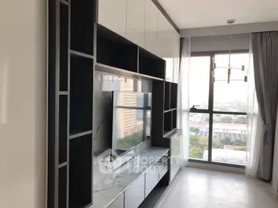 Modern living room with large window and built-in TV unit, offering a bright and airy atmosphere.