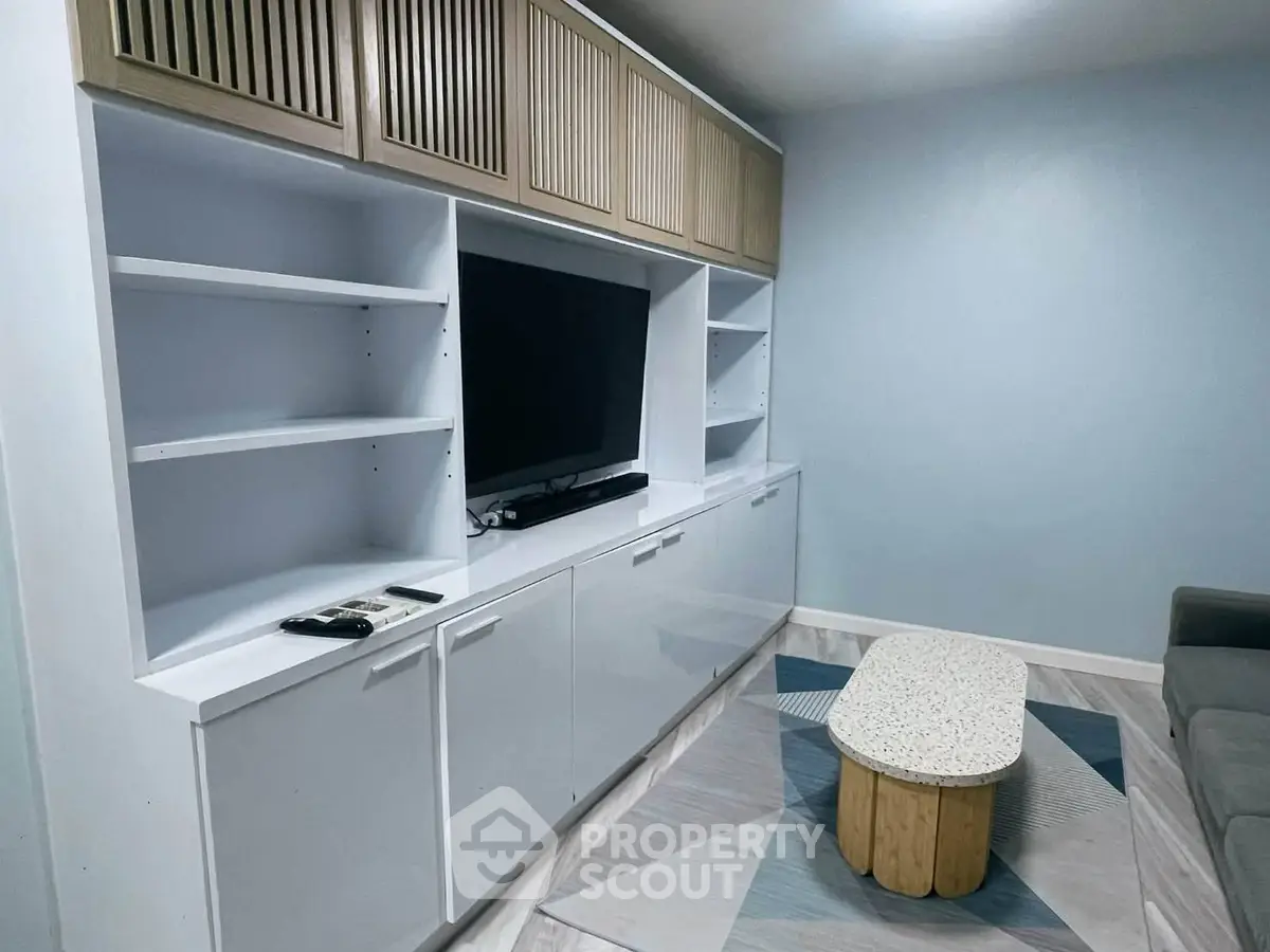 Modern living room with sleek built-in entertainment unit and stylish coffee table.